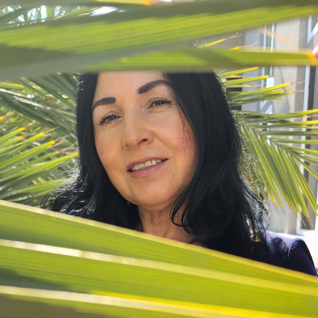 Portrait of a woman on a sunny day framed by leafy fronds Portrait of a woman on a sunny day framed by leafy fronds