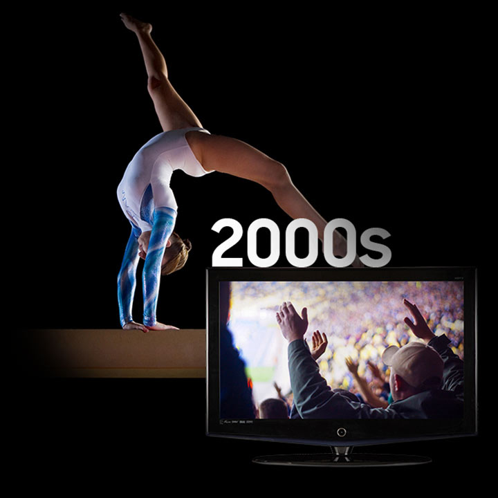 background image of a gymnast performing on a balance beam. On the screen of a 2000’s era television is a shot of a cheering crowd at a sporting event.