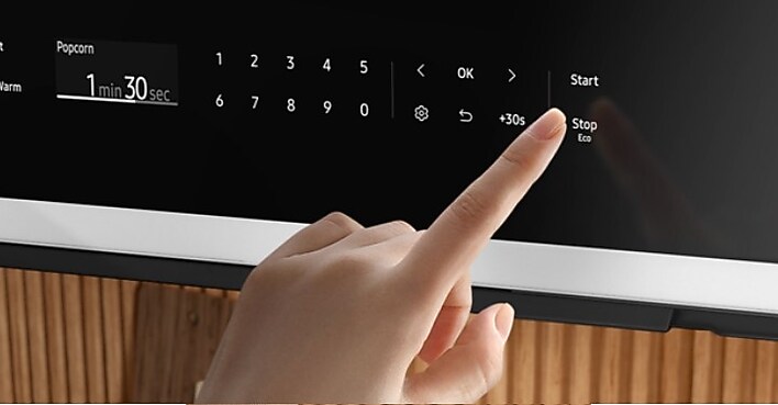 Person using touch screen on Samsung Over the Range Microwave Person using touch screen on Samsung Over the Range Microwave