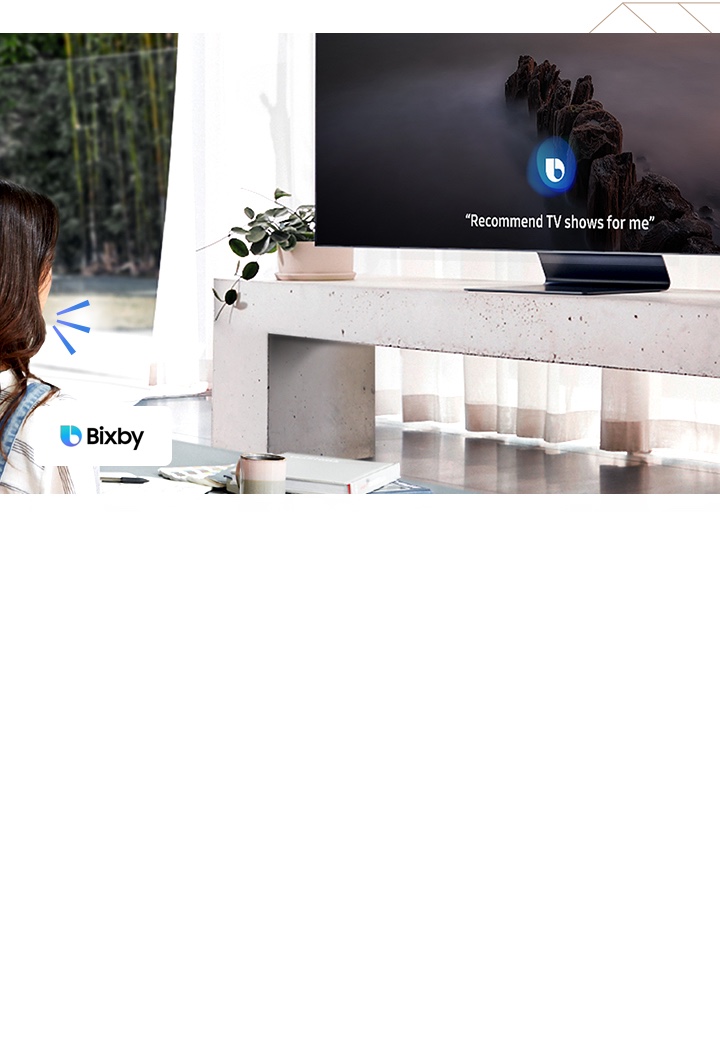 Samsung QLED TV has a voice assistant named Bixby. Speak directly to QLED, Bixby recognizes the conversation. TV onscreen is showing "Recommend TV shows for me "