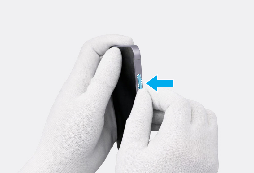 Gloved hand inserting the volume button into the side of the phone frame.