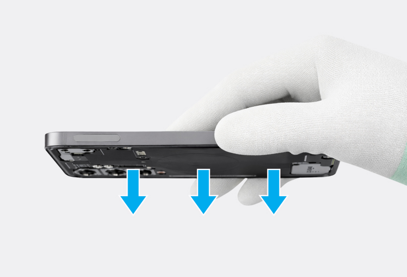 Gloved hand holding a Galaxy S25 upside down with the three down-arrow icons highlighted below the device.