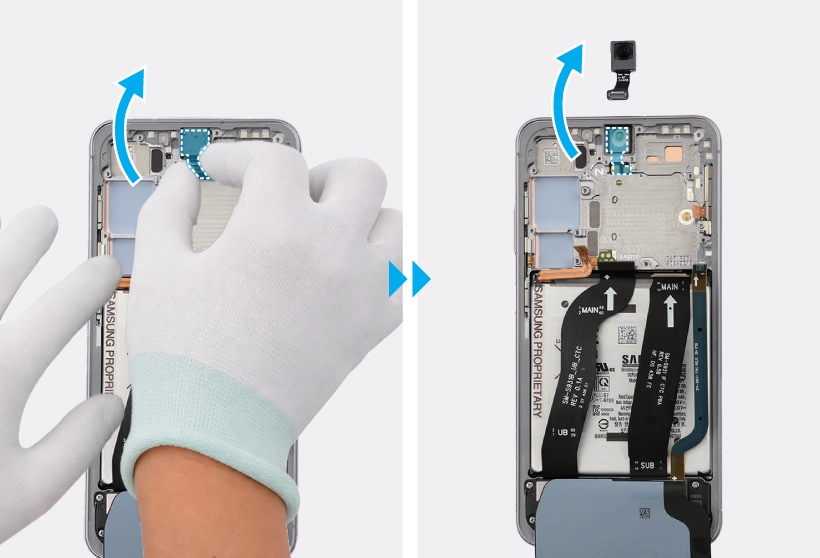 Gloved hands lifting the front camera out of the device and removing it with the camera lens facing upward.