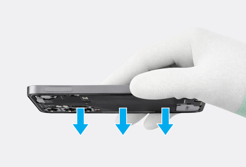 Gloved hand holding the Galaxy S25 upside down with three downward arrow icons below the device.