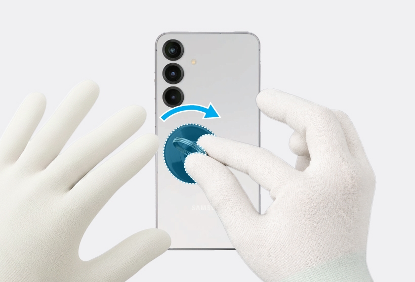 Gloved hand pulling a suction cup attached to the back of a silver Galaxy S25 Plus.
