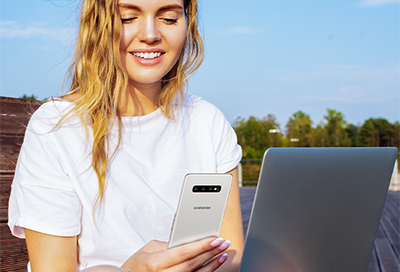 Girl using phone while sitting on a bench outside Girl using phone while sitting on a bench outside