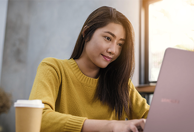 Woman in yellow sweater looking at Galaxy Book S