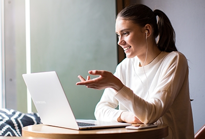 Woman looking at PC and wearing headphones Woman looking at PC and wearing headphones