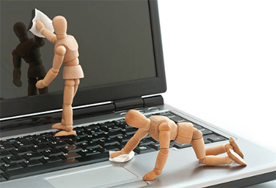 Wood figures cleaning the screen and a keyboard