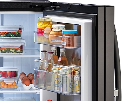Right side door of a Samsung fridge filled with condiments, juice, and soda