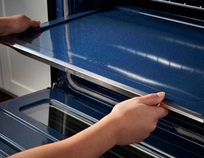 Person pulling out Flex duo divider from a Samsung oven