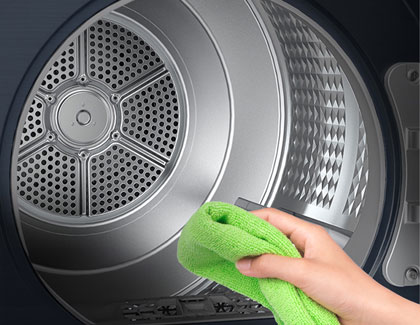 A person cleaning the inside of a Samsung dryer with a green towel.