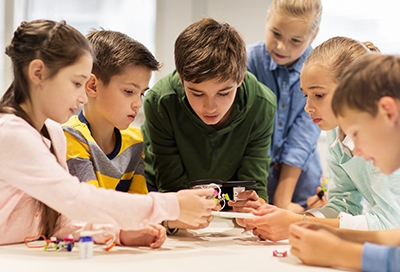 A group of children gathered around a table A group of children gathered around a table