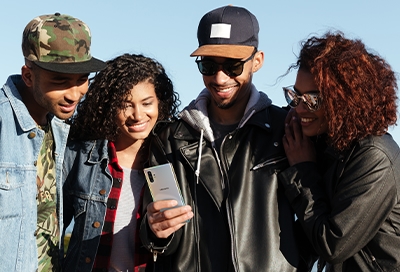 A group of people looking at a Note10 together A group of people looking at a Note10 together