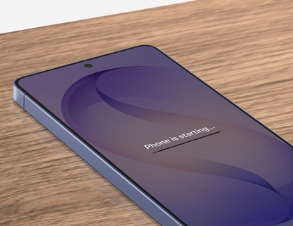 An angled close up of a Galaxy S26 Ultra on a wooden table showing a progress bar and the text Phone is starting on the screen.