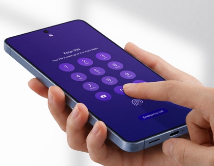 A hand holding a blue Galaxy phone and typing a PIN code on the purple lock screen to unlock the device.