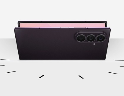 A black Galaxy Z Fold8 Ultra displayed partially folded resting horizontally on a surface showing the rear cameras and top edge.