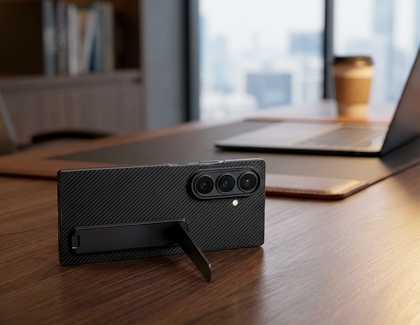 Rear view of the Galaxy Z TriFold in a black textured case standing on a table with a kickstand.