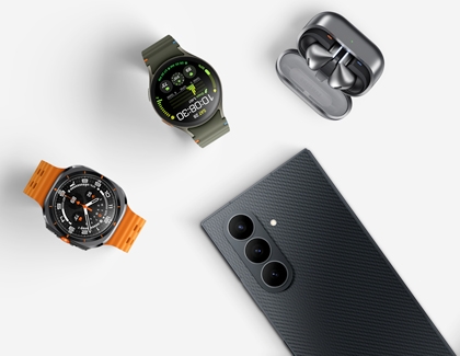 Top view of the Galaxy Z TriFold near two smartwatches and a pair of wireless earbuds in a charging case.