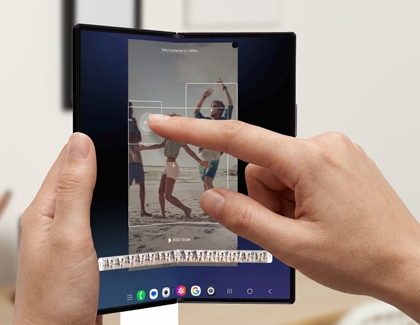 Hands holding a Galaxy Z Fold8 Ultra while selecting a person to reframe in a video.