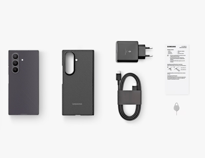 Top view of the Galaxy Z TriFold next to a case, wall charger, USB cable, quick start guide, and SIM tool.