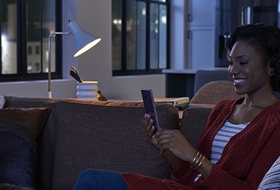 Woman on phone at home with light bulb on Woman on phone at home with light bulb on