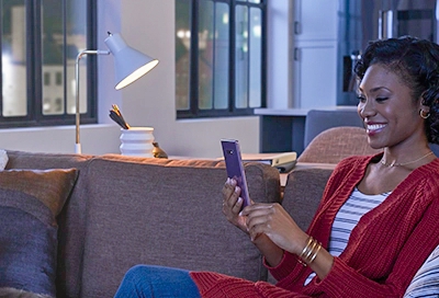 Woman on phone at home with light bulb on Woman on phone at home with light bulb on