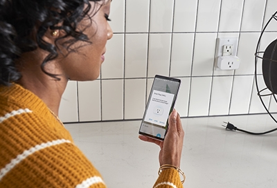Woman resetting her smart plug Woman resetting her smart plug