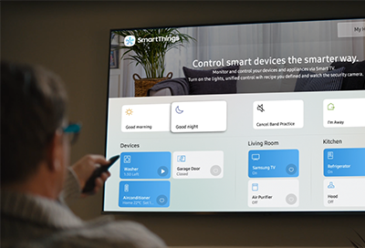 Man pointing a remote at a Smart TV Man pointing a remote at a Smart TV