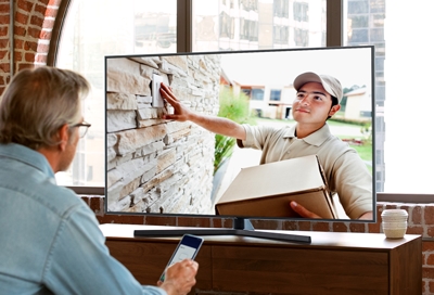 Man looking at smart TV with Ring Doorbell live feed