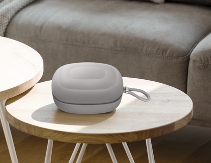 Galaxy XR carrying case placed on a round wooden table in a living room.