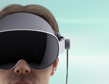 Person wearing a Galaxy XR headset connected to a power cable.