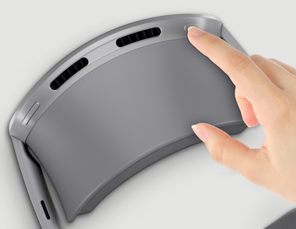 Hand pressing a top button on the Galaxy XR headset.