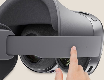 Hand pressing the touchpad on the side of a Galaxy XR headset.