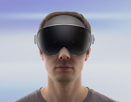 Person facing forward wearing a Galaxy XR headset against a soft blue background.
