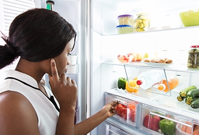 Woman considering food in the fridge