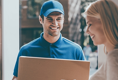 Deliveryman presenting package to a woman at her doorstep