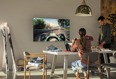 Man and women playing a racing game on their TV