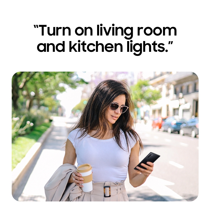 A woman using Bixby to turn on the air conditioner in advance while she is out.
