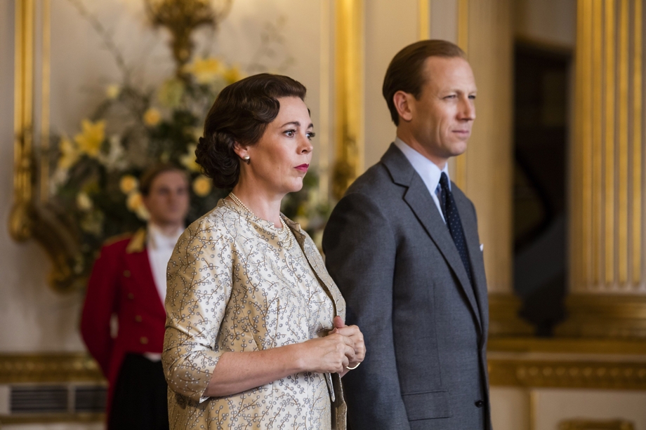 Scene from hit series The Crown via Netflix mobile app that shows characters Queen Elizabeth the 2nd and Prince Phillip standing together with steely expression on their faces