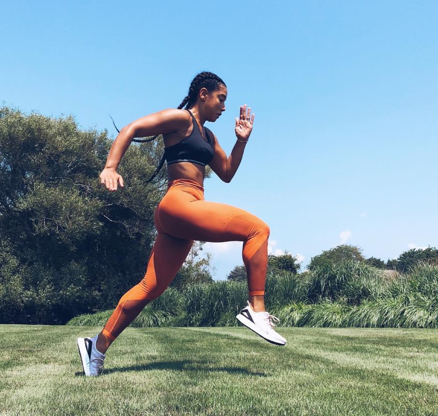 A full-body side shot of Hannah Bronfman mid-run in a park