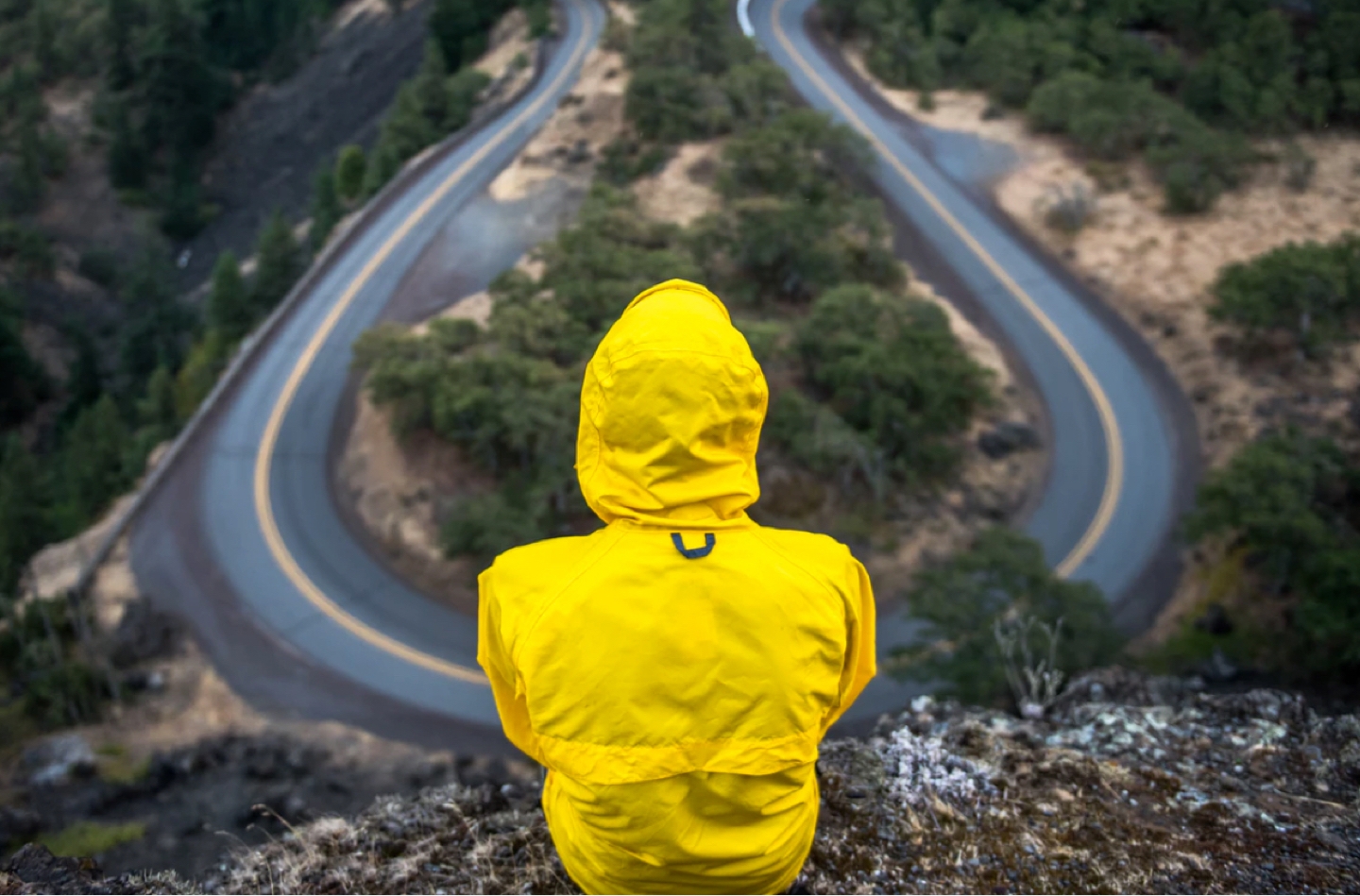 Man on top of hill looking out towards two opposite paths