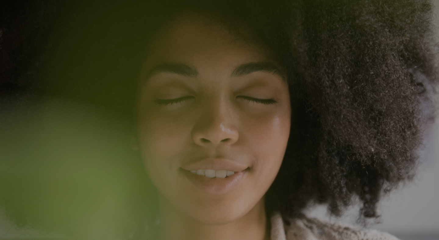 A close-up view of a woman practicing mindfulness meditation with her eyes closed