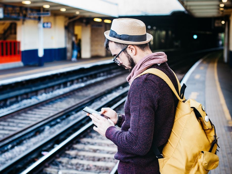Man using his Galaxy Note9 as he waits for the train