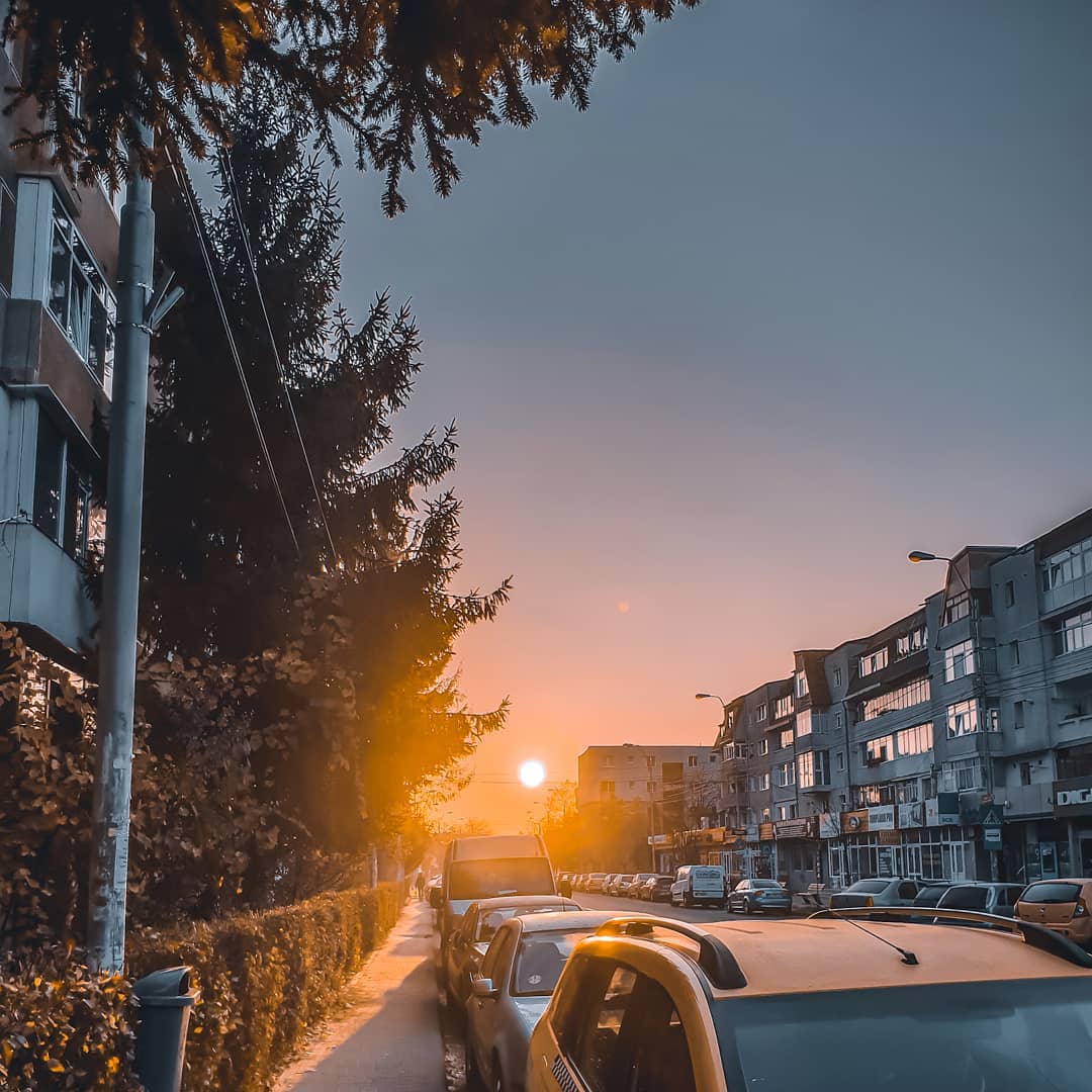 Sun setting behind parked cars.