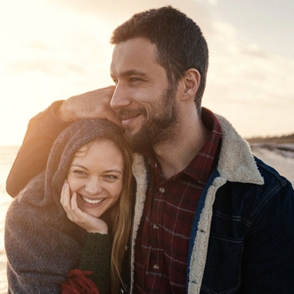 Image of happy couple on the beach to plan a date