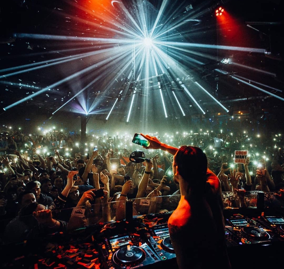 Steve captures a photo of the audience at his show in Germany from the stage using a Samsung Galaxy S10+ smartphone while the crowd holds up their flash-lit phones for ambience