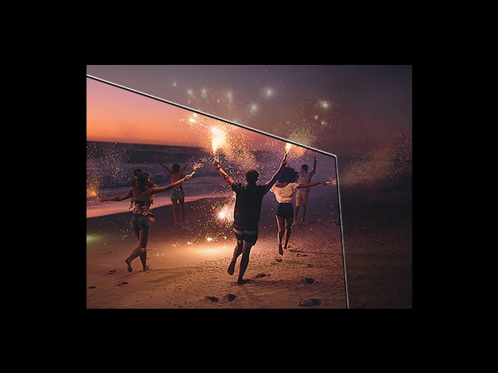 image of people with sparklers in their hands on a beach at night.   