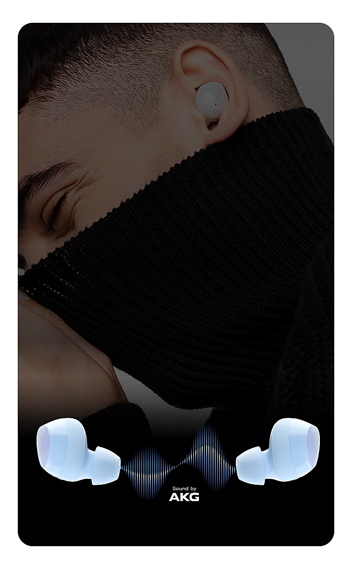 A man with a closely cropped hair is seen from the side wearing the buds in his left ear. He is also pulling up a turtleneck sweater playfully above his nose. Below him is an image of the buds tilted outward with a blue sign wave graphic between them along with the text "Sound by AKG"