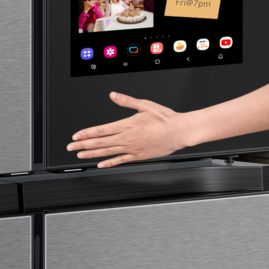 Persons hand using touch screen on Samsung Family Hub refrigerator
